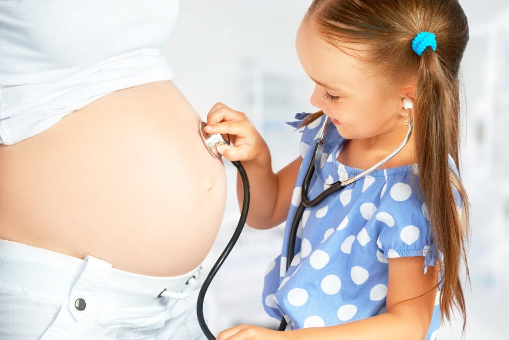 Dcéra sa hrá na doktorku a matke poskytuje vyšetrenie stetoskopom v tehotestve